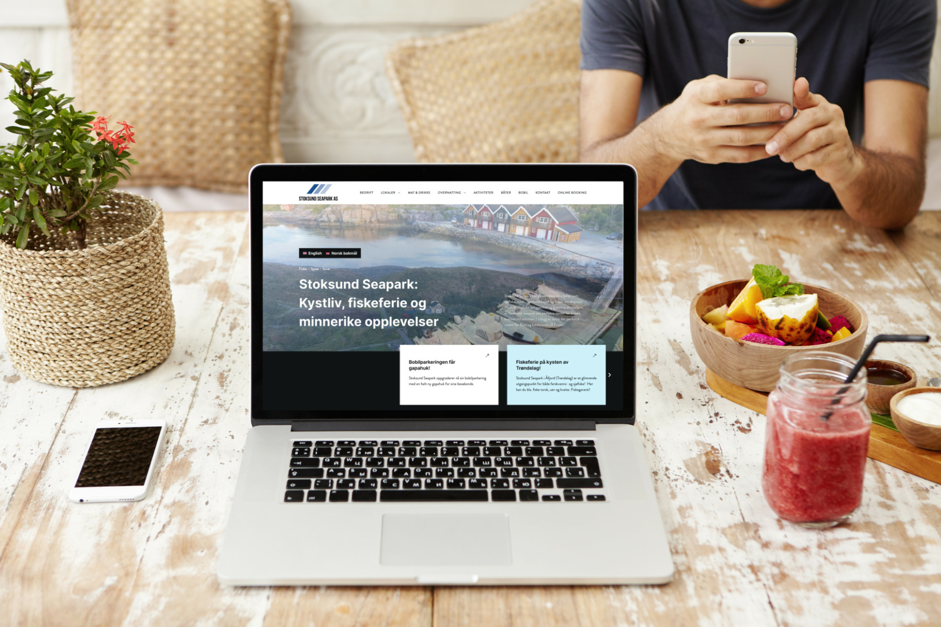 Technology, business, communication, people and advertisement. Front view of wooden designer workplace with open laptop with blank screen, cell phone, glass of smoothie and bowl of fruits. Mock up